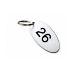 Custom engraved key holder tags in round plastic discs with sequential room numbers for property management key tracking.